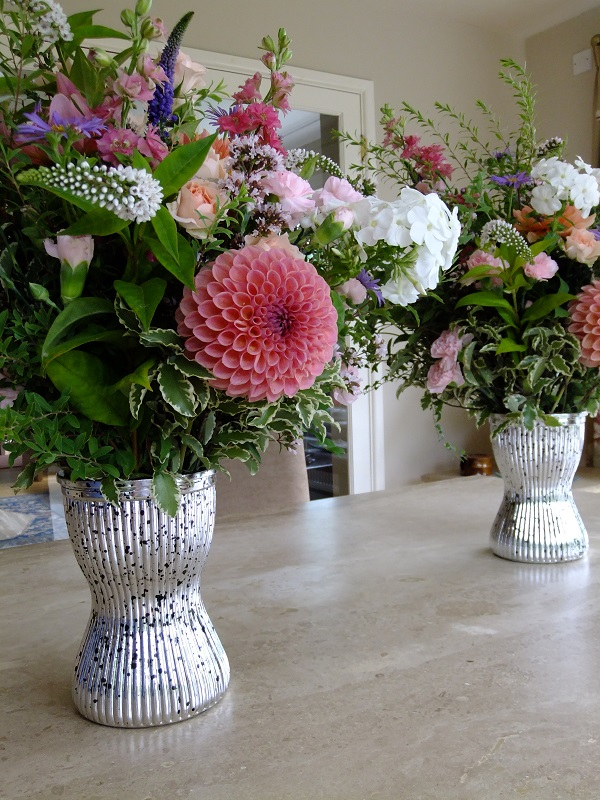 Peachy pink dahlias are the feature bloom in these christening arrangements. Flowers by Honey Pot Flowers